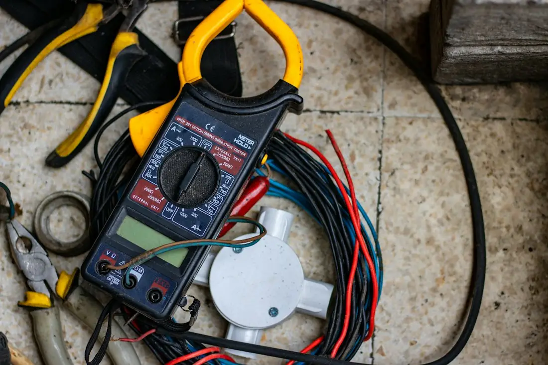 Pince ampèremétrique posée sur des câbles électriques